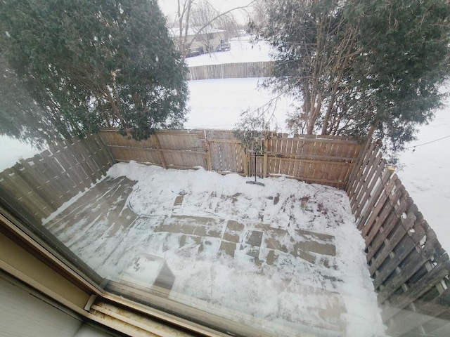 yard layered in snow featuring a fenced backyard