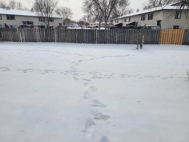 snowy yard featuring fence