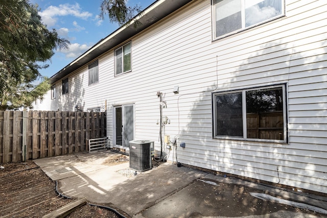 back of property featuring fence, cooling unit, and a patio area