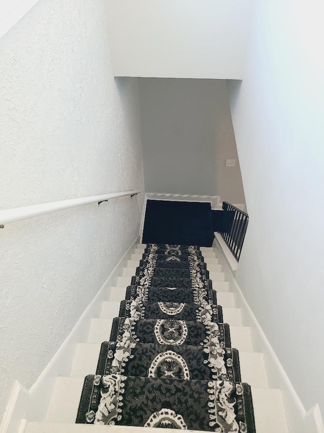 staircase featuring a textured wall