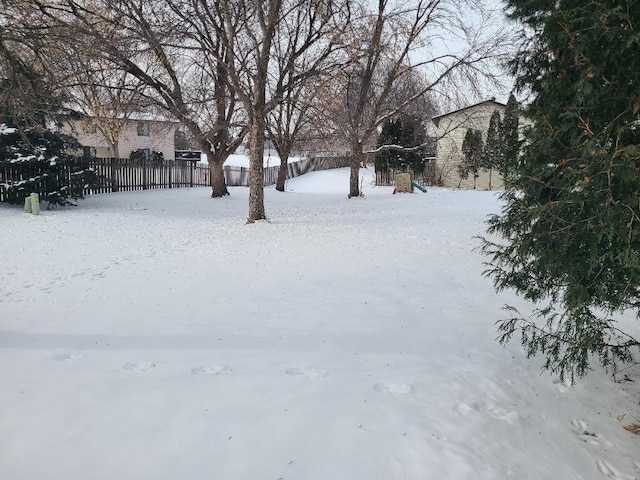 yard covered in snow featuring fence