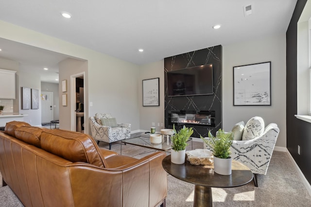 carpeted living room featuring a high end fireplace