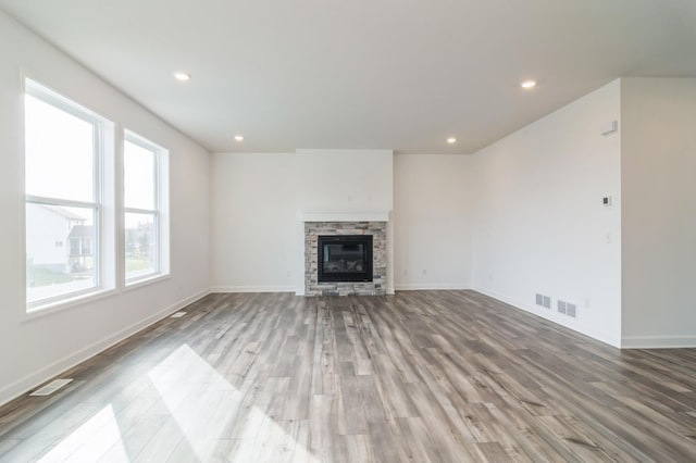 unfurnished living room featuring a fireplace and hardwood / wood-style flooring