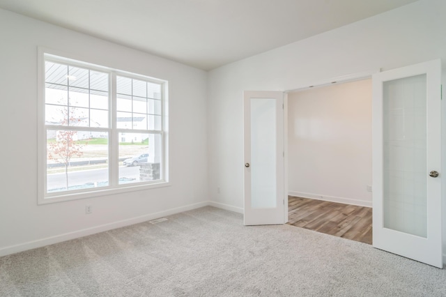 unfurnished bedroom featuring light carpet and french doors