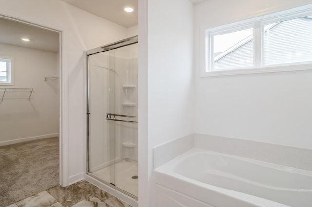 bathroom featuring shower with separate bathtub