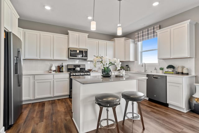 kitchen featuring white cabinetry, pendant lighting, stainless steel appliances, and a center island