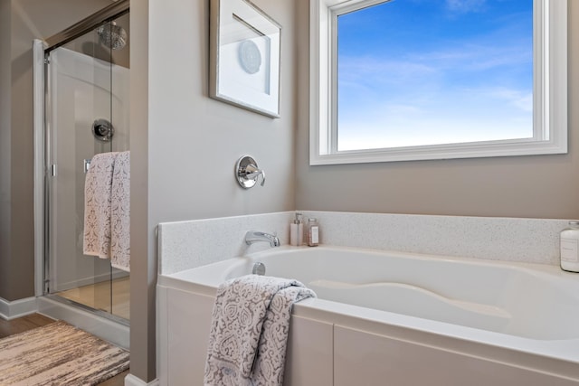 bathroom featuring wood-type flooring, a wealth of natural light, and shower with separate bathtub