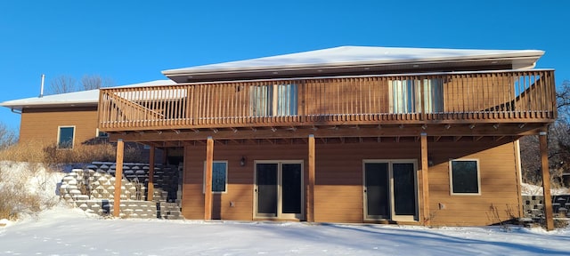 snow covered property with a deck