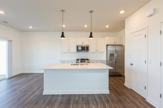 kitchen with stainless steel appliances, dark hardwood / wood-style flooring, white cabinets, and a kitchen island with sink