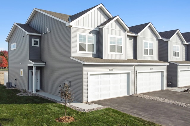 townhome / multi-family property featuring a garage, a front yard, and central AC