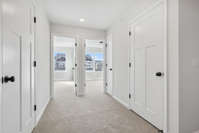 hall featuring light colored carpet