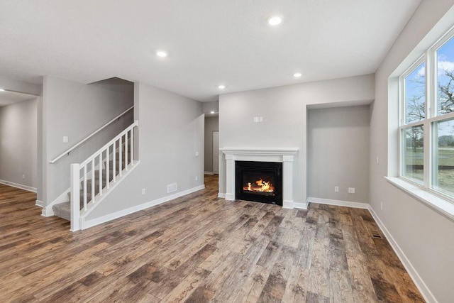 13621 Aulden Ave, Rosemount, MN 55068 - unfurnished living room with wood finished floors, stairway, recessed lighting, a warm lit fireplace, and baseboards