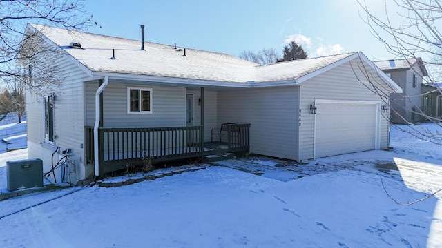 view of front of property with covered porch, central air condition unit, and a garage