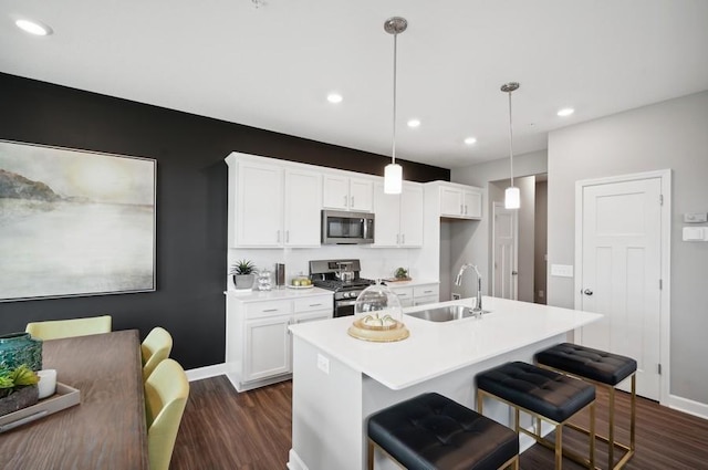 kitchen with white cabinetry, hanging light fixtures, and appliances with stainless steel finishes