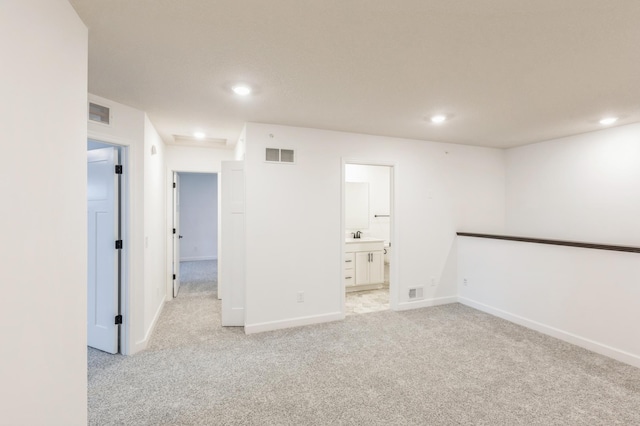 empty room with light colored carpet and sink