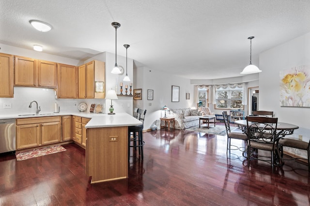 kitchen with sink, dishwasher, decorative backsplash, decorative light fixtures, and kitchen peninsula