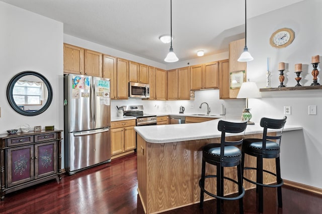 kitchen featuring sink, kitchen peninsula, pendant lighting, stainless steel appliances, and decorative backsplash