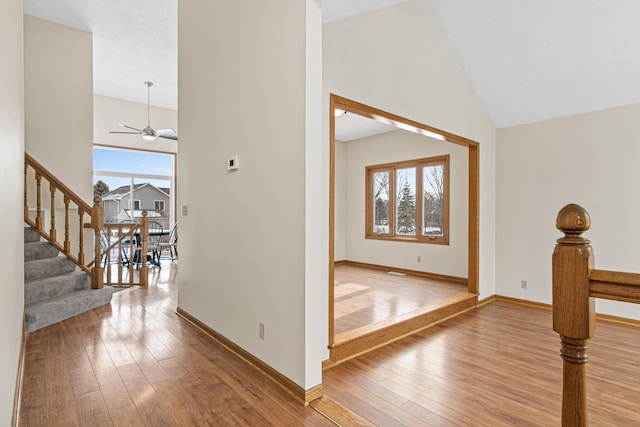 entryway with ceiling fan, wood-type flooring, and high vaulted ceiling