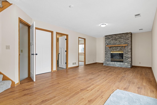 unfurnished living room featuring a fireplace and light hardwood / wood-style floors