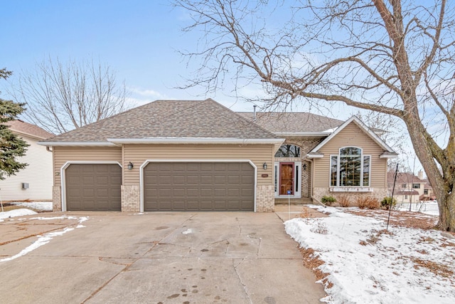 ranch-style home featuring a garage, a shingled roof, concrete driveway, and brick siding