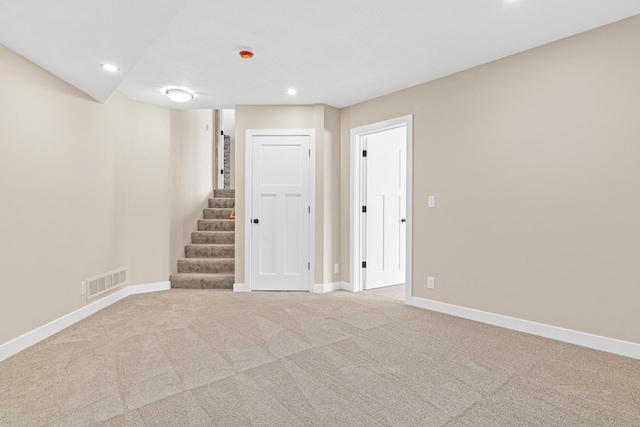 below grade area with recessed lighting, visible vents, light carpet, baseboards, and stairs