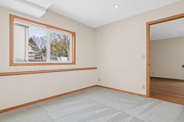 spare room featuring carpet, baseboards, and recessed lighting