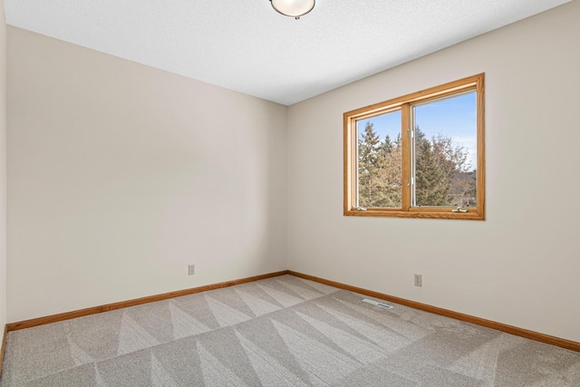 unfurnished room featuring visible vents, baseboards, and light colored carpet