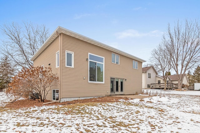 snow covered back of property with french doors