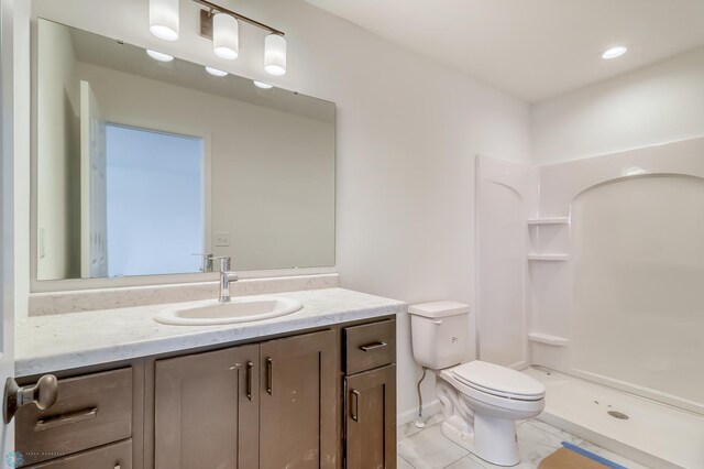 bathroom with vanity, tile patterned floors, toilet, and a shower