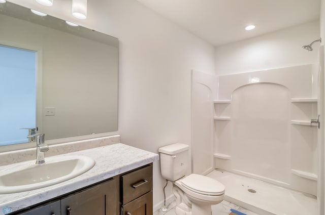 bathroom with walk in shower, vanity, and toilet