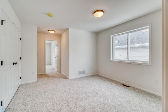 spare room featuring light colored carpet