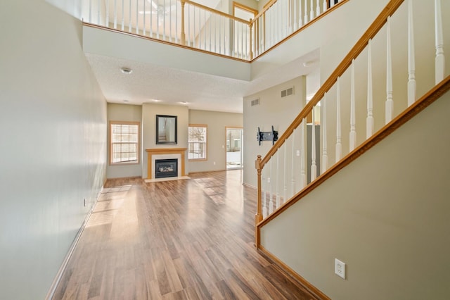 unfurnished living room featuring a high ceiling and hardwood / wood-style flooring