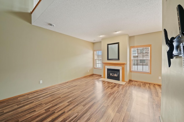 unfurnished living room featuring a textured ceiling and light hardwood / wood-style floors