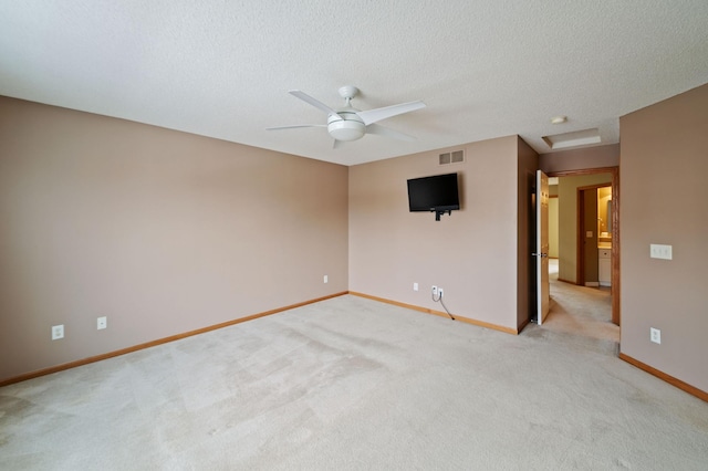 empty room with a textured ceiling, ceiling fan, and light colored carpet