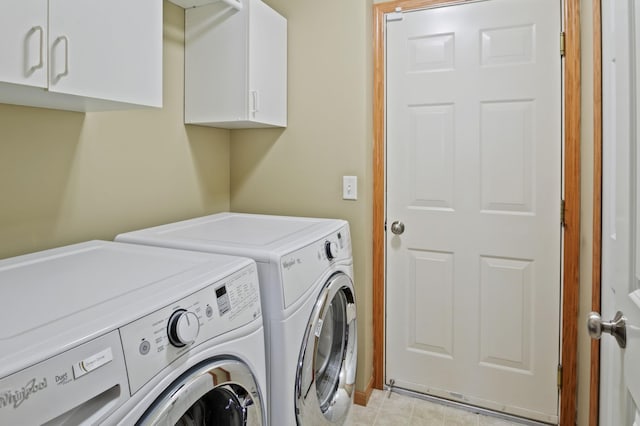 clothes washing area with washing machine and dryer and cabinets