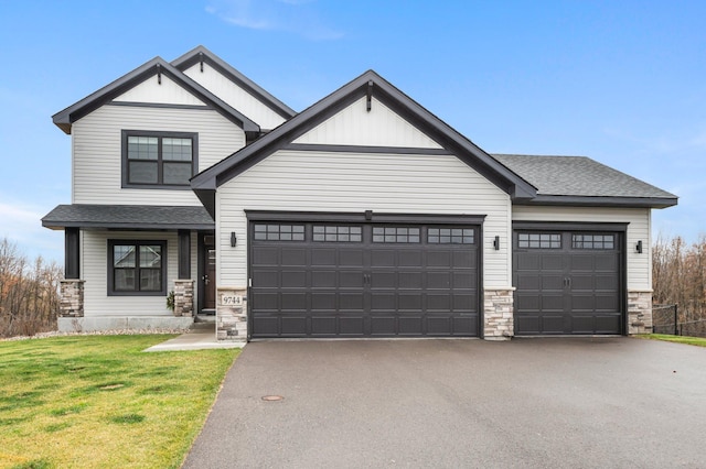 craftsman house with a front lawn and a garage