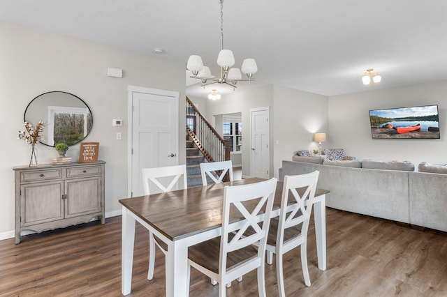 dining area with dark hardwood / wood-style floors and a notable chandelier