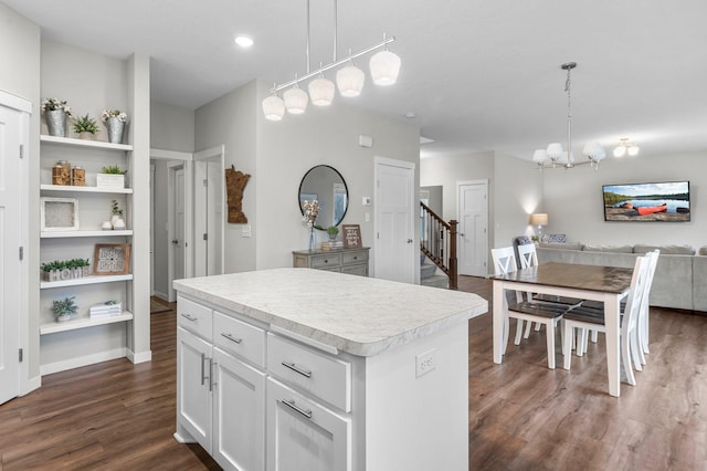 kitchen with dark wood-type flooring, decorative light fixtures, white cabinetry, and a center island