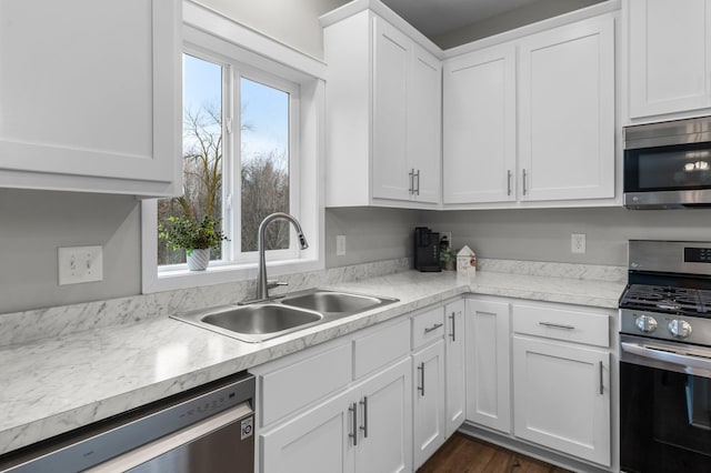 kitchen with dark wood-type flooring, white cabinets, appliances with stainless steel finishes, and sink