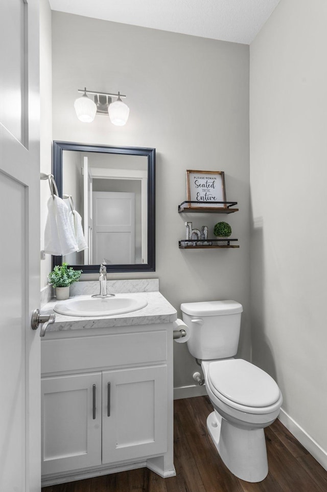 bathroom with toilet, vanity, a textured ceiling, and hardwood / wood-style flooring