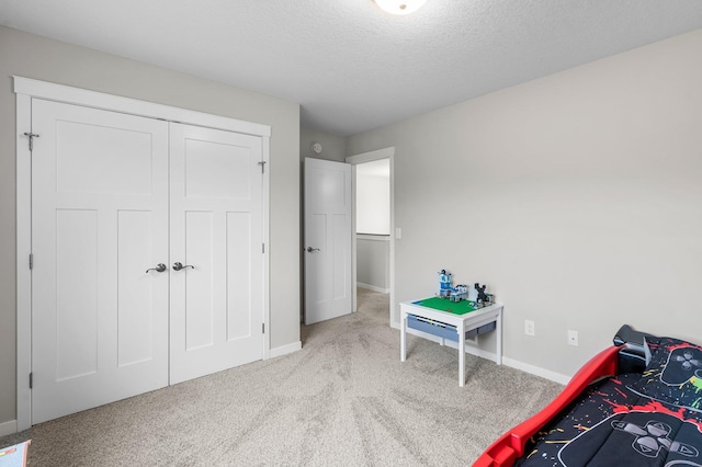 carpeted bedroom with a textured ceiling and a closet