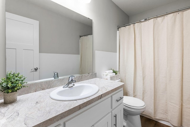 bathroom with hardwood / wood-style floors, toilet, and vanity