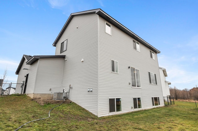 back of property with cooling unit and a yard