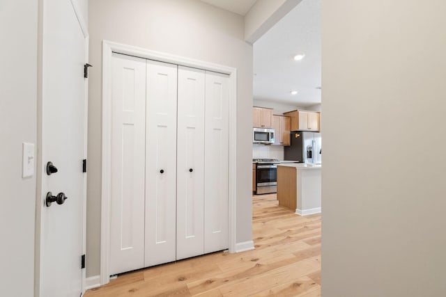 hall featuring recessed lighting, baseboards, and light wood-style floors