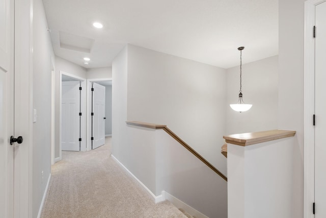 corridor featuring recessed lighting, baseboards, an upstairs landing, and carpet