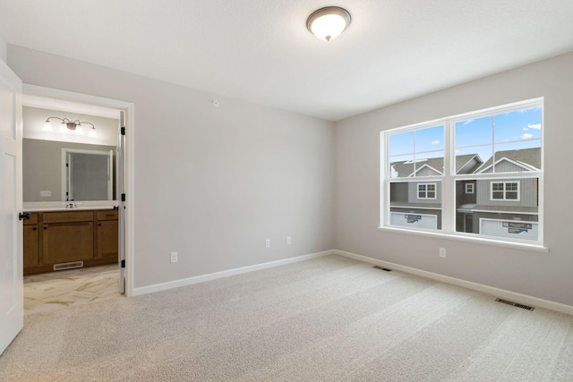 unfurnished bedroom featuring baseboards, visible vents, and light carpet