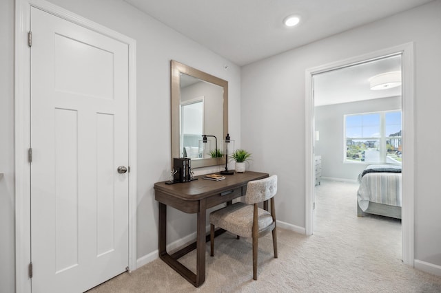 office space featuring baseboards and light colored carpet