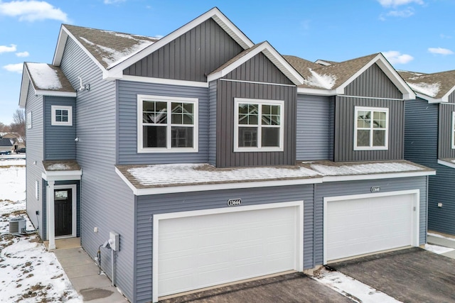 view of front of house with a garage and central air condition unit