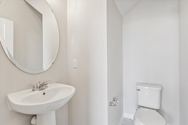 bathroom with sink, vaulted ceiling, and toilet