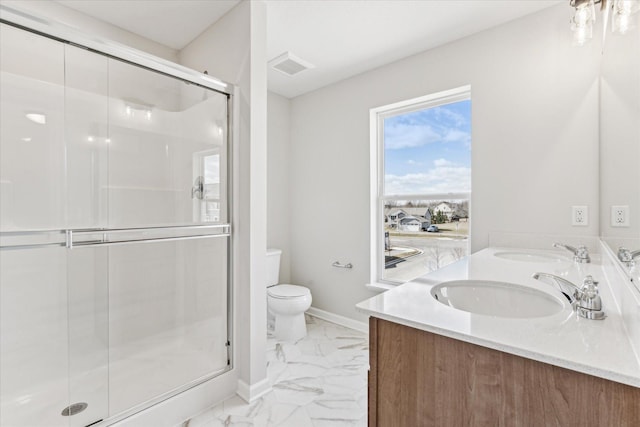 bathroom featuring vanity, toilet, and a shower with shower door